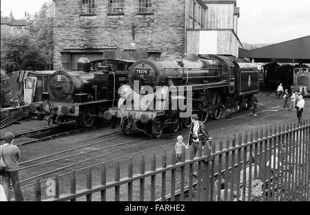 La gare de Haworth, dans le Yorkshire de l'Ouest vers 1982 Photographie noir et blanc image d'archive. Accueil de la Concon et chemin de fer de la vallée d'une valeur, le KWVR est assuré par des bénévoles. Cour avec des moteurs à vapeur, de travail et de la protection du moteur. Banque D'Images