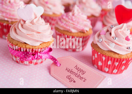 Valentine rose cupcakes avec les mots "Happy Valentine's day' sur une étiquette. Banque D'Images