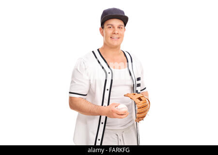 Jeune homme dans un uniforme de baseball baseball une holding et regardant la caméra isolé sur fond blanc Banque D'Images