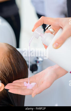 Styliste est occupé à laver les cheveux. Banque D'Images