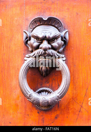 Doorknocker face démon sur une porte en bois Banque D'Images