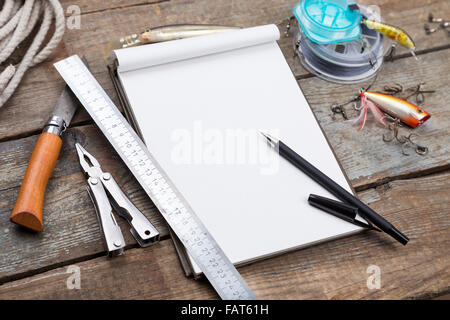 L'écriture blanche-livre avec des matériels de pêche et d'outils de conception sur planche de bois. pour l'impression, maquette, conception. Banque D'Images