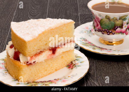 Une tranche de gâteau éponge Victoria et une tasse de café avec de la vaisselle ornée d'antiquités - studio shot. Banque D'Images