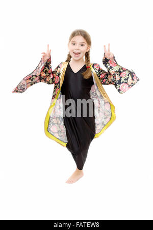 Young Girl playing dress up portant un kimono japonais et montrant la victoire sur fond blanc Banque D'Images