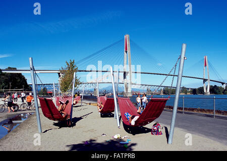 New Westminster, Colombie-Britannique, Canada - des hamacs sur la plage urbaine à Westminster Pier Park, sur la rivière Fraser Skybridge Banque D'Images