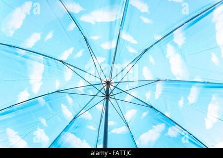À l'intérieur d'un parapluie avec des nuages blancs dans un ciel bleu. Une référence à Magritte ou d'optimisme et de réflexion positive. Banque D'Images