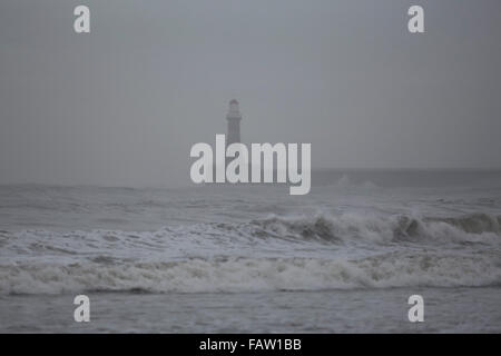 Roker phare sur une journée grise de la pluie à Sunderland, en Angleterre. La jetée et le phare s'étendent dans la mer du Nord. Banque D'Images