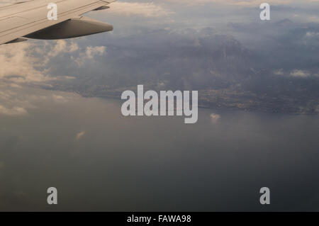 Lac de Garde (Vénétie, Italie) et le coucher du soleil sur l'ailette de bout d'avion vue aérienne du hublot d'aéronefs Banque D'Images