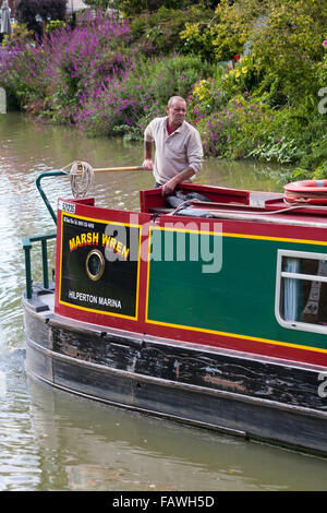 Homme à bord d'un bateau étroit narrowboat sur le canal de Kennet et Avon, Devizes, Wiltshire, Angleterre au Royaume-Uni en août Banque D'Images