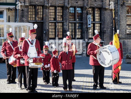 Les hommes et les jeunes garçons dans la St Cecilia Kon Harmonie Band attendre pour jouer leurs instruments dans Grote Markt Leuven Belgique Banque D'Images