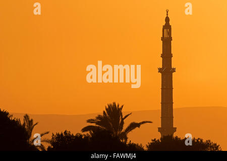 Minaret silhouetté contre coucher du soleil orange près de Louxor, Egypte Banque D'Images