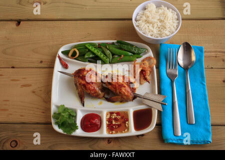 Poulet grillé mariné Thai-Lao avec salade de pois snap Banque D'Images