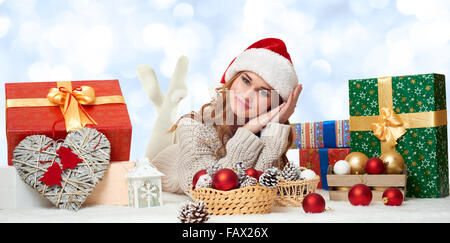 Belle jeune fille se trouvent à santa hat avec boîtes cadeaux - maison de vacances concept Banque D'Images