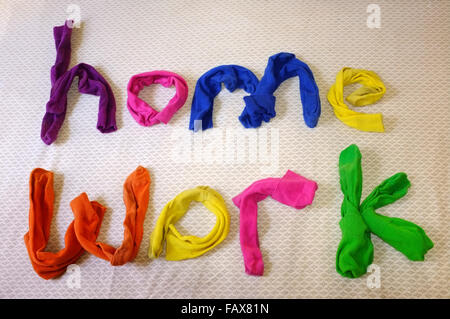 Les mots accueil travaux faits de chaussettes colorées portant sur une couette. Banque D'Images