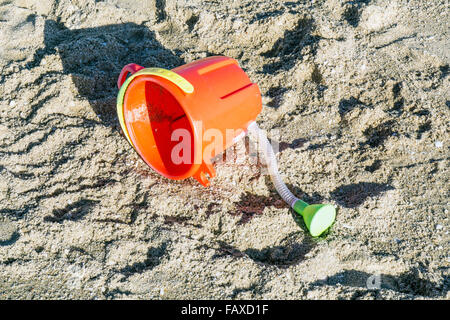 Arrosoir plastique orange vif avec bec verseur et poignée jaune vert jouet pour enfant à gauche sur la plage de Playa las Conchas Sonora State Banque D'Images