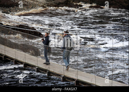 Touristes traversant le pont suspendu au-dessus de la rivière tempêtes embouchure à Tsitsikamma National Park en Afrique du Sud Banque D'Images