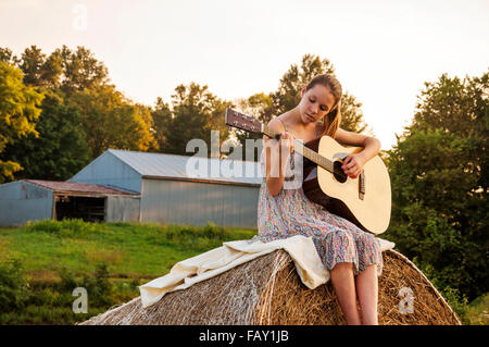 Fille avec la guitare sur farm Banque D'Images