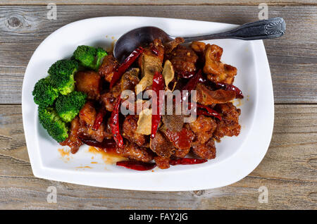 Angle de vue élevé plat chinois composé de tofu frit, poivrons rouges, et le brocoli. Grande cuillère de service sur le côté de la plaque avec Banque D'Images