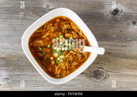 Angle de vue élevé le tofu, le chou et la soupe à l'oignon vert avec cuillère en bois rustique sur bol. Banque D'Images