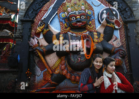 Katmandou, Népal. 6 janvier, 2016. Les femmes ''geste Namaste'' tout en posant pour une photo devant une idole de New World Bhairav à Hanuman Dhoka Square, Katmandou, Népal, le mercredi 6 janvier 2016. Place Kathmandu Durbar est répertorié dans le patrimoine mondial de l'UNESCO. © Skanda Gautam/ZUMA/Alamy Fil Live News Banque D'Images