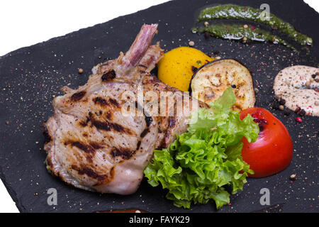 Côtelettes de veau grillées sur l'os avec la sauce et les légumes, gros plan Banque D'Images