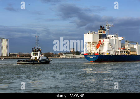 Remorqueur de guidage d'un grand porte-conteneurs grâce à l'étroite entrée du port de Portsmouth. À la suite de remorqueur à l'arrière du vaisseau principal. Banque D'Images