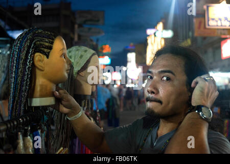 Vendeur de perruques à Kao San Road, Bangkok, Thaïlande. Modélisation de tressage de cheveux mannequins retour packers, Khao San Road, Bangkok, Thaïlande, Banglamphu Banque D'Images