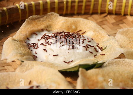 Serabi Solo, le lait de coco crêpes du solo, avec des vermicelles de chocolat ajouté. Mis sur bambou tressé traditionnel bac. Banque D'Images