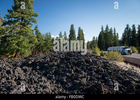 Un semi-remorque sur la rivière McKenzie Highway traverse des champs de lave et forêt en comté de Linn, Oregon. Banque D'Images