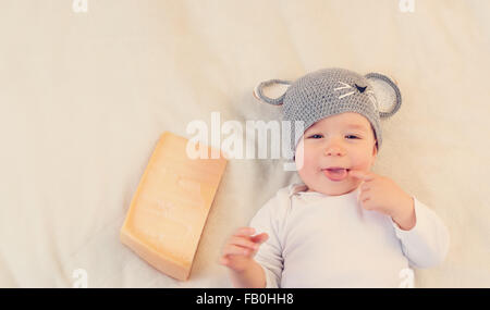 Baby Boy in mouse hat lying on blanket avec du fromage Banque D'Images