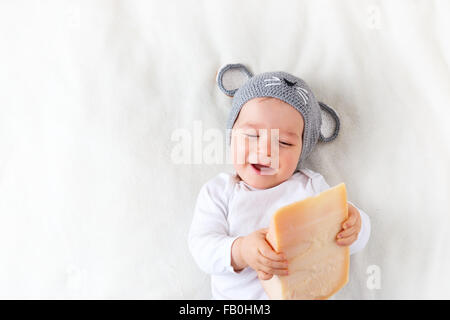 Baby Boy in mouse hat lying on blanket avec du fromage Banque D'Images