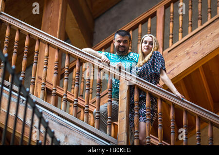 Jeune couple debout sur une échelle en bois vintage à la Chambre. Banque D'Images