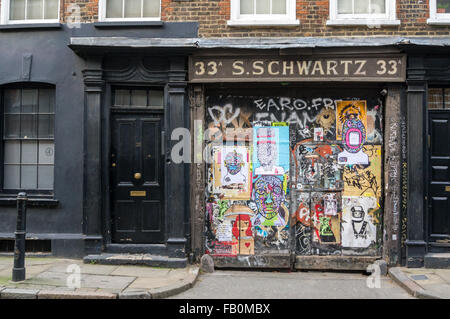 Graffiti sur une porte de 33A, Rue Fournier, anciennement l'entreprise de S. Schwartz, Spitalfields, East London, England Banque D'Images