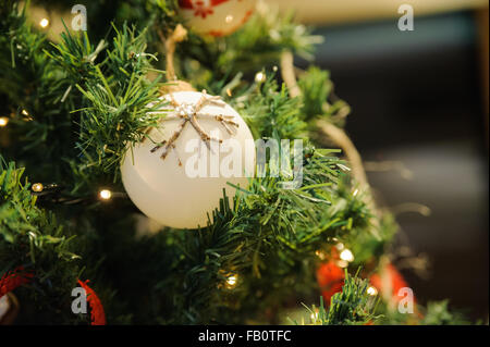 White Christmas ornament hanging sur une branche d'arbre Banque D'Images