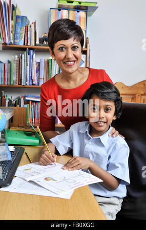 Jeune garçon avec sa mère faire ses devoirs après l'école Banque D'Images