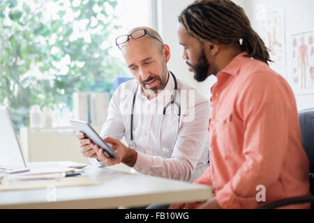 Donner au patient consultation médecin using digital tablet Banque D'Images