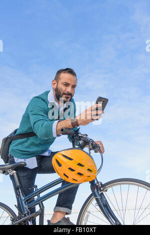 L'homme avec l'aide de vélo téléphone Banque D'Images