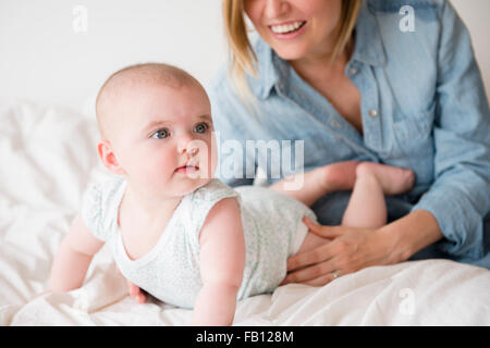 Baby Girl (4-5) with mother on bed Banque D'Images