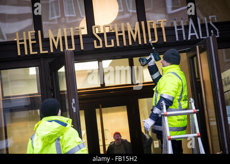 Hambourg, Allemagne. Jan 7, 2016. Les hommes définir la nouvelle 'lettrage Helmut-Schmidt-Haus' sur l'entrée de l'immeuble anciennement connu sous le nom de 'Pressehaus' dans le centre de Hambourg, Allemagne, 7 janvier 2016. La maison d'édition de l'hebdomadaire Die Zeit est en train de changer son nom en l'honneur de l'éditeur de longue date et l'ancien chancelier allemand Helmut Schmidt (1918-2015). PHOTO : CHRISTIAN CHARISIUS/DPA/Alamy Live News Banque D'Images