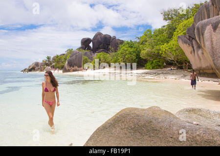 Belle femme posant sur la célèbre source d'argent de la plage de sable blanc avec palmiers, le 27 septembre 2015 dans la passe, la Digu Banque D'Images