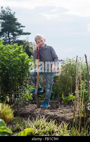 Portrait of boy creuser dans le jardin biologique Banque D'Images