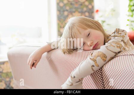 Portrait de sleepy boy leaning on salon canapé Banque D'Images