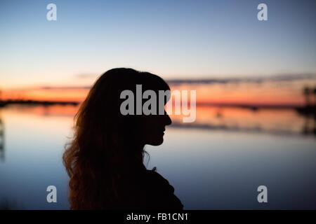 Vue latérale du jeune femme en silhouette sur l'eau Banque D'Images