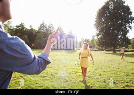 Jeune couple à jouer au badminton dans le parc ensoleillé Banque D'Images