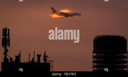 Un Airbus A380 Lufthansa en venant d'atterrir à l'aéroport de Frankfurt am Main, Allemagne, 07 janvier 2016. La lumière du matin illumine la vapeur autour de l'avion. Le nouveau bâtiment de la tour Henninger Turm peut être vu en bas à droite. PHOTO : FRANK RUMPENHORST/DPA Banque D'Images