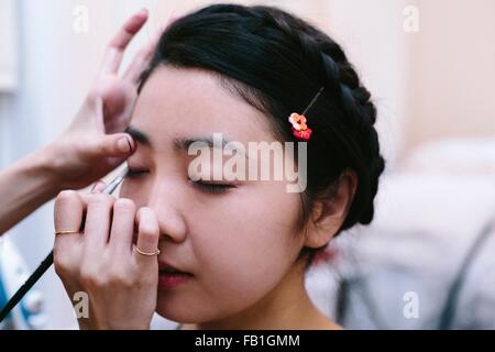 Mains de l'artiste composent l'application constituent en jeune femme avec les yeux fermés Banque D'Images