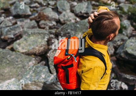 Portrait of mid adult man sac à dos de couleur orange, le lac Moraine, Banff National Park, Alberta Canada Banque D'Images