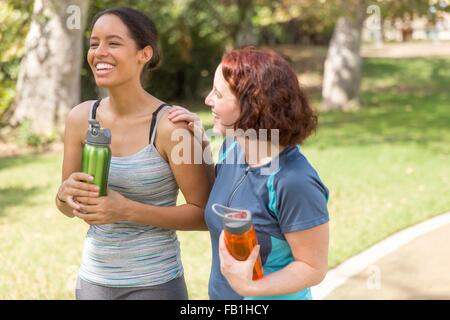 Portrait de jeunes femmes portant des vêtements de sport en portant de l'eau bouteilles smiling Banque D'Images