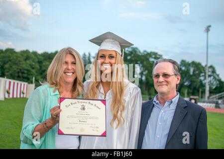 Portrait of young female graduate avec leurs parents à la cérémonie de remise de diplômes Banque D'Images