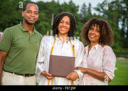 Portrait of teenage girl avec leurs parents à la cérémonie de remise de diplômes Banque D'Images